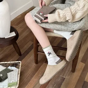 Primo piano di calzini da donna in stile giapponese con ricamo di cucciolo e fiocco.