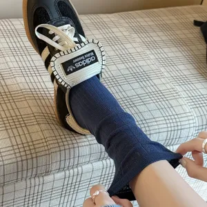 Vintage dark blue knit mid-calf socks with delicate pattern, styled with sneakers for daily wear.