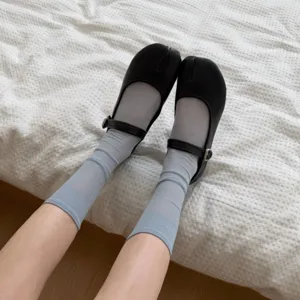 Comode calze con dita in rete traspirante abbinate ad eleganti scarpe Tabi nere.