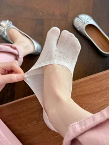 Detail view of thin summer Tabi split-toe invisible socks with subtle knit bow pattern.