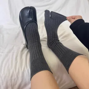Detailed shot of grey ribbed split toe tabi socks, showing great stretch and fashion pairing.
