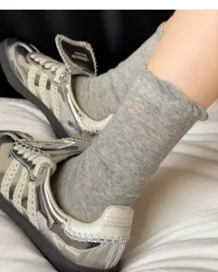 Grey cotton mid-calf socks featuring delicate bow knit patterns and cute ruffled cuffs.