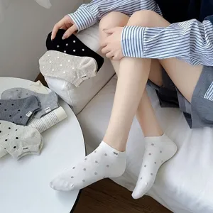 Detailed view of women's short boat socks with cute polka dots and a stylish Nice woven label.