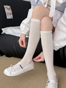 Detailansicht weißer Mesh-Kniestrümpfe mit feiner Spitzenborte und Tupfen im japanischen Stil.