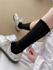 Schwarze Netz-Langsocken mit Pünktchen-Muster und Spitzenbesatz, atmungsaktives Detail.
