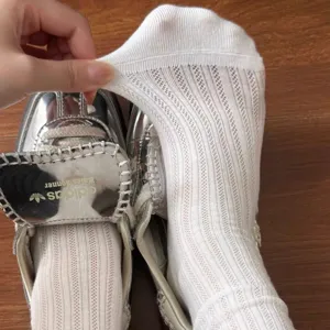 Vue detaillee de chaussettes ete femme blanches ajourees montrant le tissu elastique et doux.