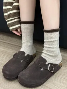 Close-up detail of cozy winter wool blend rolled cuff mid-calf socks in light grey tone.