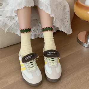 Detail view of women contrast ruffle socks, retro cotton mid tube socks paired with sneakers.