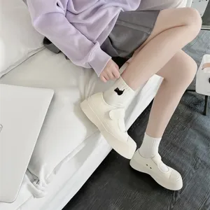Detail view of cute platform shoes and embroidered cat socks, casual college style outfit.