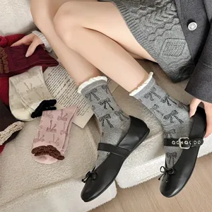 Korean ins style grey mid-calf socks featuring all-over black bow prints and cute bubble ruffles.