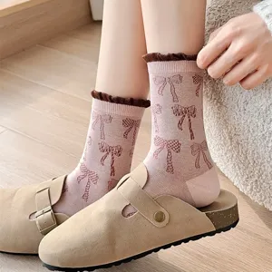Cozy pink mid-tube socks for women featuring cute brown bow patterns and stylish contrast ruffles.