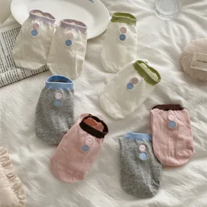 Detail of breathable mesh short socks with cute button embroidery and soft cotton fabric.
