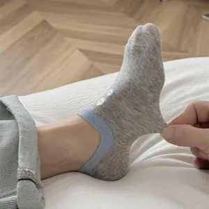 Detail view of women cotton short socks, light grey boat socks with button embroidery.