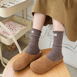 Detail shot of cozy brown ribbed knit crew socks with cute small label, lifestyle footwear.