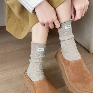 Close-up detail of Japanese style solid color ribbed slouch socks with cute mini label.