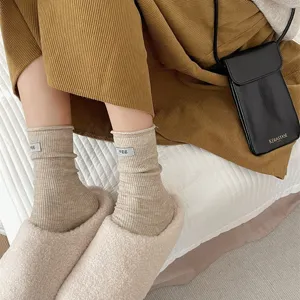 Detailed close-up of Japanese rolled edge slouch socks, soft solid color knit fabric.