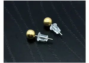 Boucles d'oreilles boules dorées avec fermoirs en plastique transparent, vue de détail.