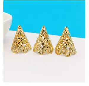 Close-up detail of golden cone filigree bead caps, vintage metal DIY craft accessories.
