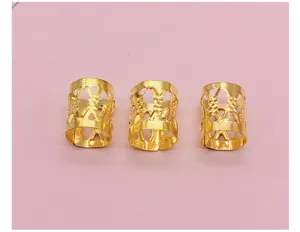 Close-up view of golden hollow dreadlock rings, perfect DIY hair styling accessories for braids.