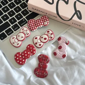 Retro red bow hair clips featuring cute cherry and dot prints, perfect for daily sweet styling.