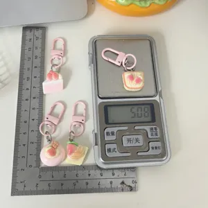 Vue détaillée du porte-clés gâteau aux fraises mignon, pendentif de sac à main créatif.
