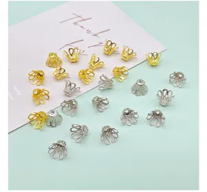Close-up detail of mixed gold and silver metal flower bead caps for DIY jewelry crafting.