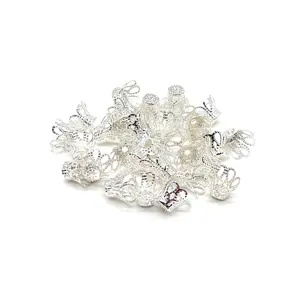 Close-up detail of silver metal filigree flower bead caps for DIY hair accessories crafting.