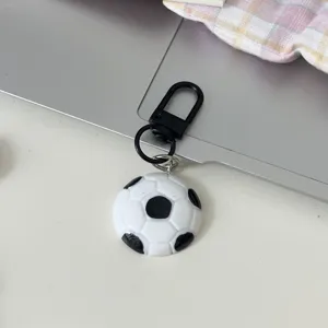 Soccer ball keychain detail view, black and white football bag charm with metal clasp, casual.