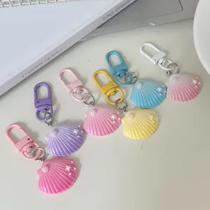 Colorful gradient pearl shell keychains closeup, cute bag charm pendant for daily accessories.