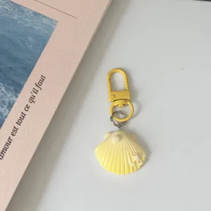 Yellow seashell keychain with pearl detail, cute bag pendant and chic accessory gift.