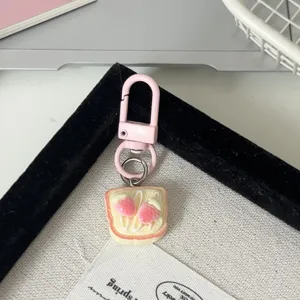 Vue détaillée porte-clés toast fraise mignon, fermoir métal rose, charm de sac dessert doux.