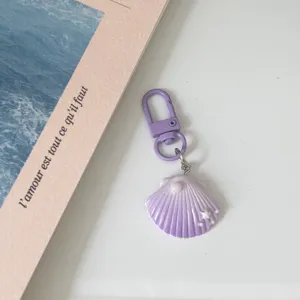 Purple gradient shell keychain detail, cute pearl and star decor, resin bag charm accessory.