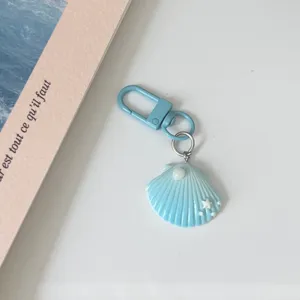 Blue gradient shell keychain detail view, featuring cute pearl and star accents with metal clasp.