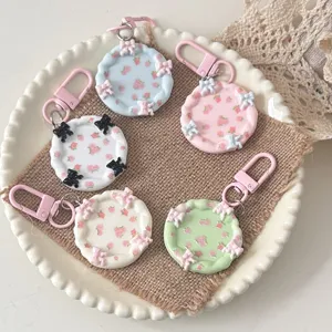 Süße Makronen-Miniaturteller-Schlüsselanhänger mit Blumen und Schleifen für Taschen.
