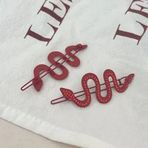 Red snake hair clips set featuring matte metal and rhinestone studded serpent design for women.
