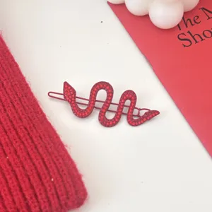 Close-up detail of the red rhinestone snake hair clip, featuring sparkling crystals and secure grip.
