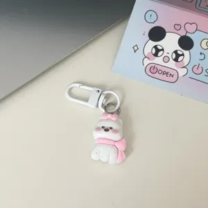Simpatico portachiavi a cagnolino bianco con fiocco e sciarpa rosa, ideale accessorio per zaino.
