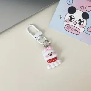 Dettaglio portachiavi cucciolo bianco carino con ciondolo cane resina fiocco rosa sciarpa pois.