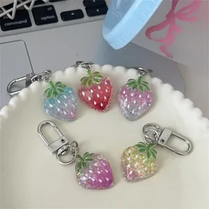Detail view of transparent gradient strawberry keychain with glitter, cute bag charm pendant for women.