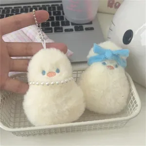 Plush duck keychain detail showing cute fluffy pendant with pearl necklace and blue bow.