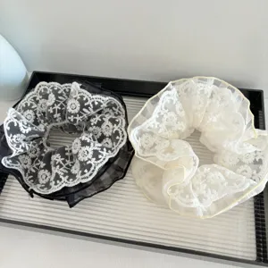 Vue détaillée de chouchous en dentelle multicouche, montrant une texture florale délicate.