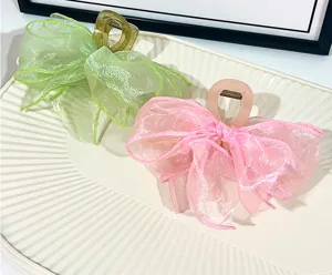 Dettaglio molletta per capelli fiocco organza primo piano verde pastello rosa accessorio.