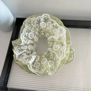Chouchou en dentelle verte vue de detail, accessoire de coiffure elegant en maille florale.