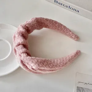 Dettaglio fascia in maglia, accessorio capelli lana rosa morbido, design elegante per uso quotidiano.