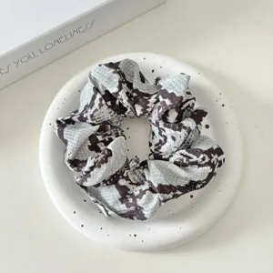 Detailed view of the chic retro animal print fabric hair scrunchie, soft ruffled texture.