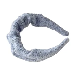 Cerchietto largo in maglia azzurra con nodo e texture morbida, stiloso accessorio.