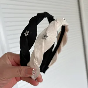 Twisted fabric headband with rhinestone star, chic black and white hair accessory for women detail view.