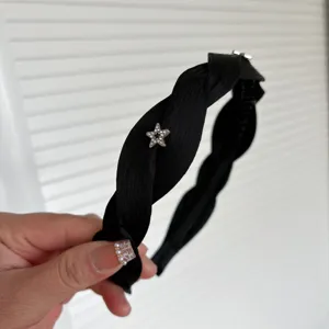 Black braided headband featuring a sparkling rhinestone star detail, stylish hair accessory.