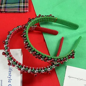 Close-up detail shot of Christmas headbands wrapped in velvet with red and green jingle bells.