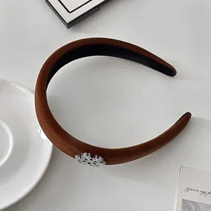 Detailed close-up view of the brown velvet headband with a sparkling snowflake detail.